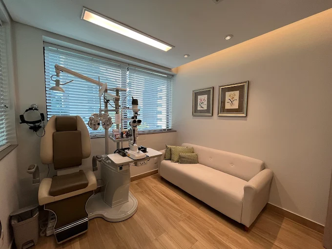 Sala de atendimento oftalmológico com equipamentos e sofá